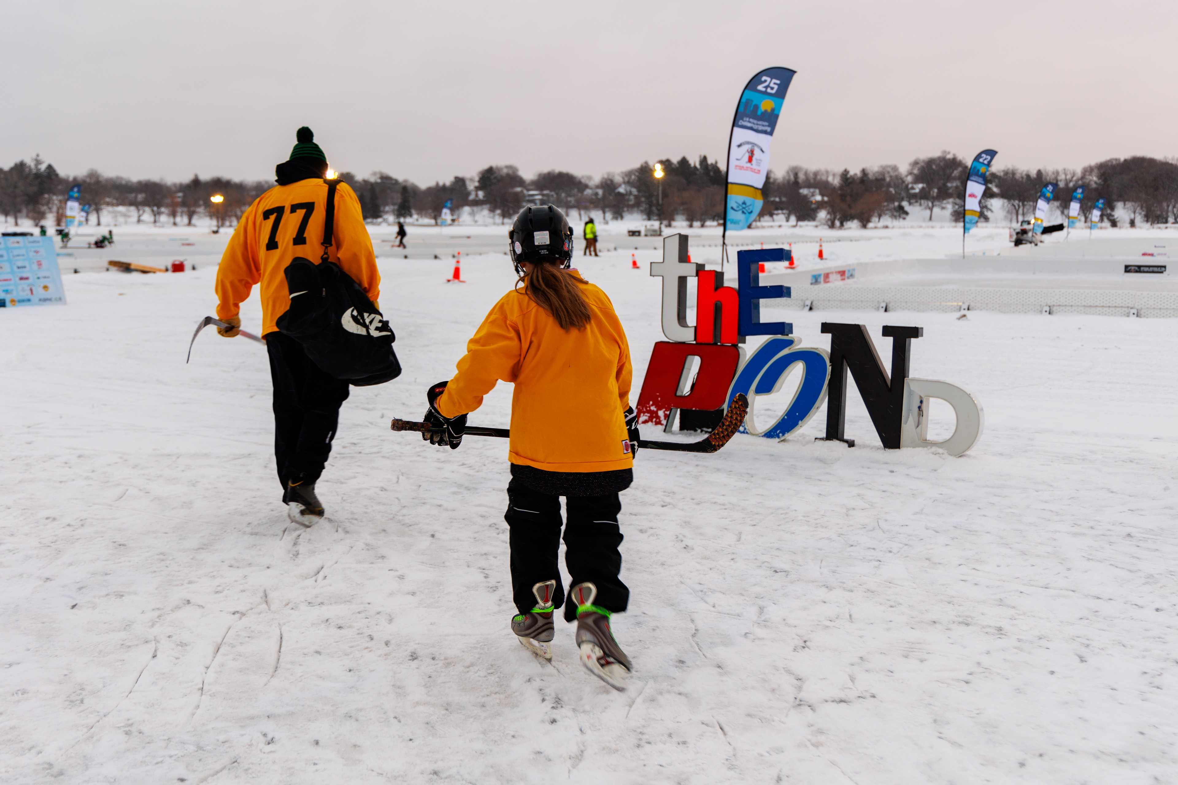 Coach and youth hockey player walking out to pond hockey rink