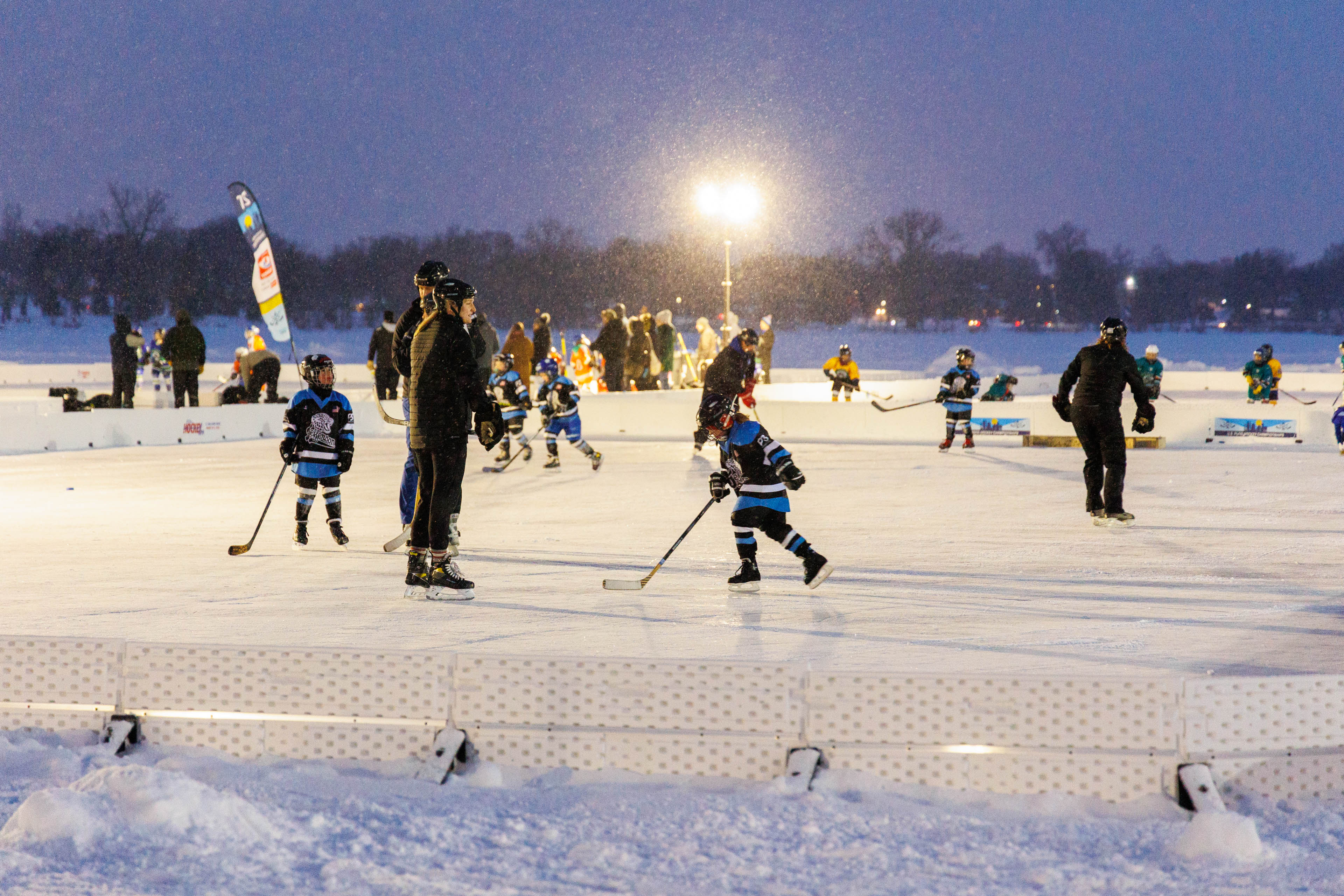 Youth hockey players playing pond hockey under the lights.