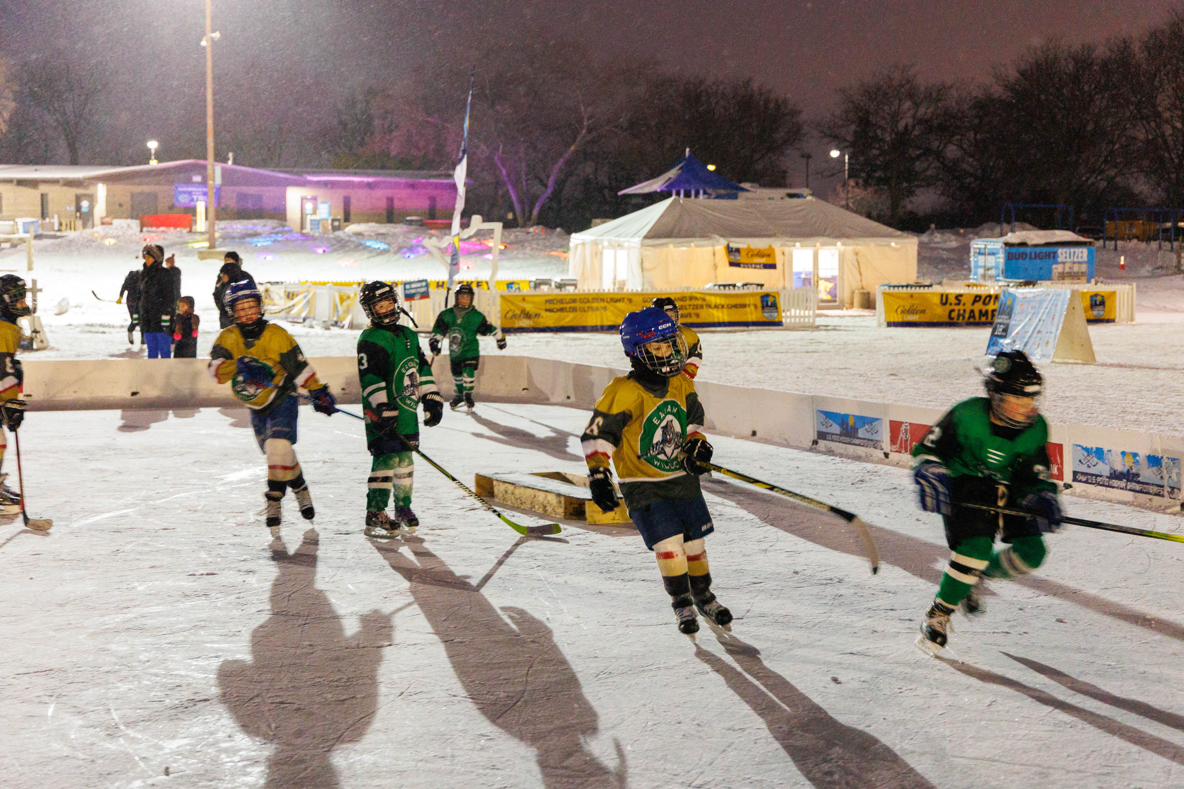 Youth athletes playing hockey at night