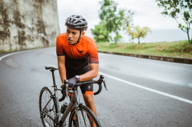 Tired cyclist while riding his bike outdoor