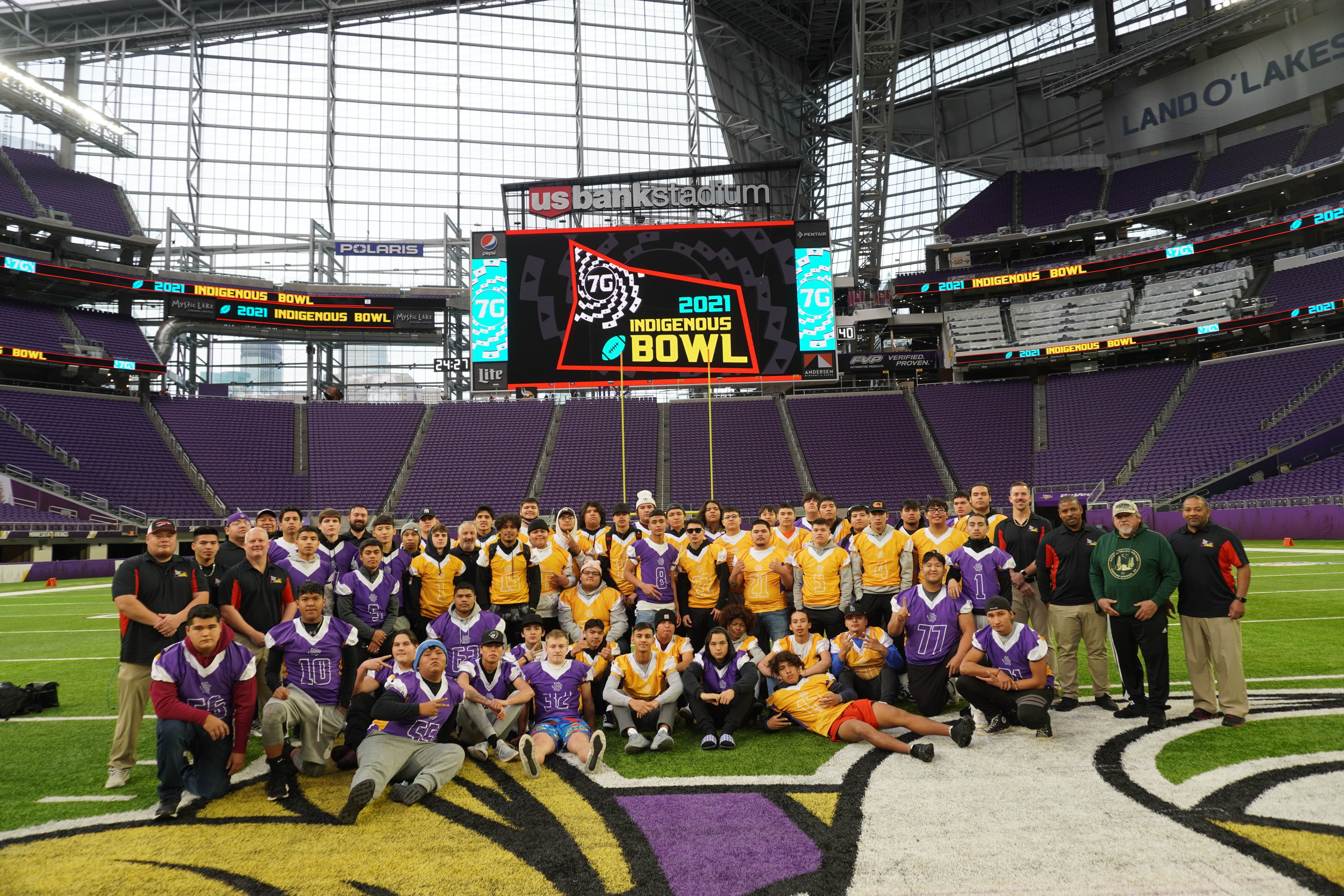Team photo of Indigenous bowl players on the field at Vikings Stadium