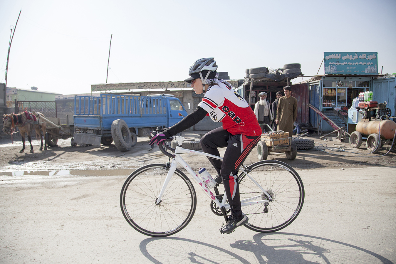 Afghan Cycles woman riding bike through town
