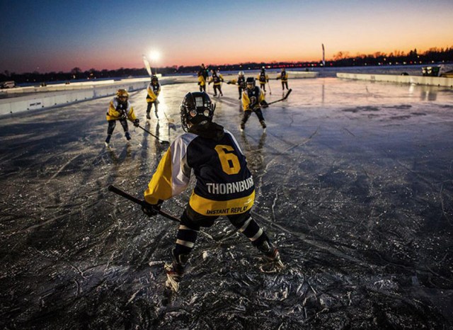 Youth athletes playing hockey at night