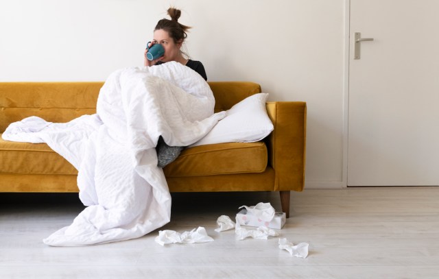 A woman feeling sick in a modern living room.