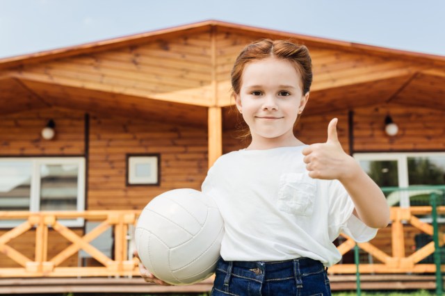girl giving thumbs up with volleyball