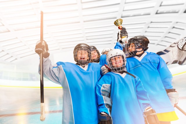 Ice hockey team holding trophy above their heads