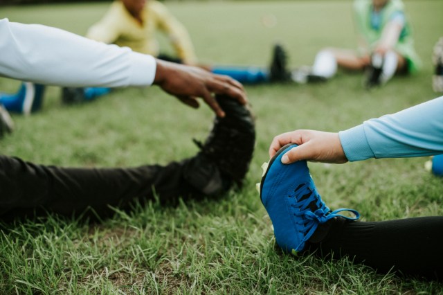 Close up of kids stretching on the field