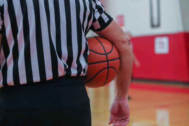 A basketball referee holds a ball during a timeout