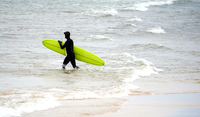 November 9 2013 St Joseph MI USA; a surfer dons a wet suit to brave cold waters in lake michigan