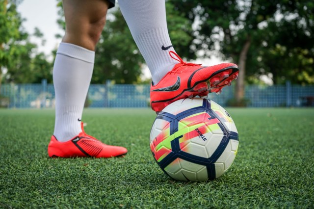 A player is training football on pitch by wearing Nike "Phantom Venom Elite" which is for striker.