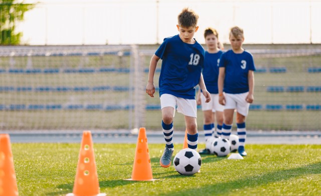 Child dribbling a soccer ball at practice