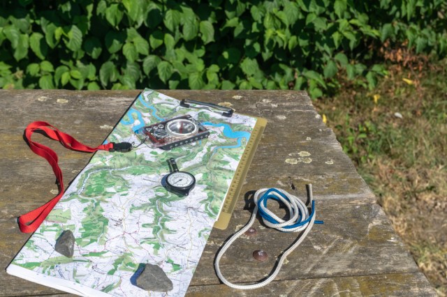 A map on a table. Opisometer, a curvimeter, a map measurer.