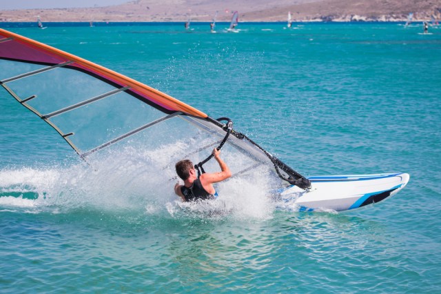 Young man learning to windsurf in the sea at beautiful turqouise water - Cesme, izmir