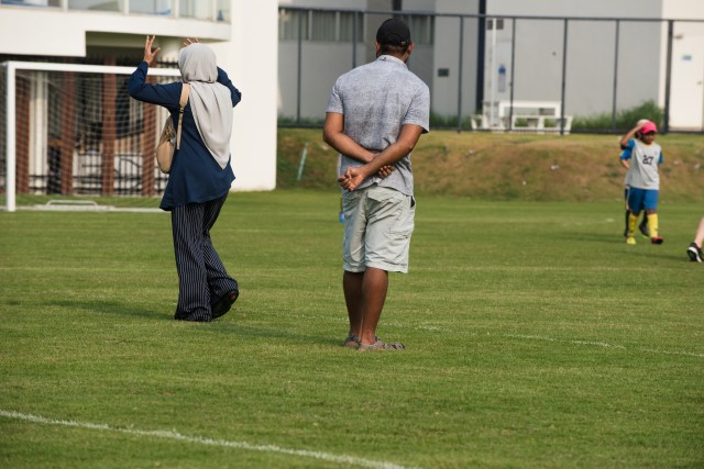 Parents watching their son from the sidelines