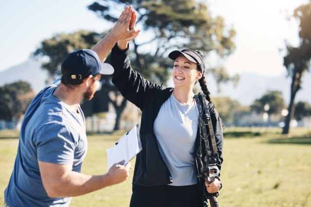 Archer and coach high fiving.