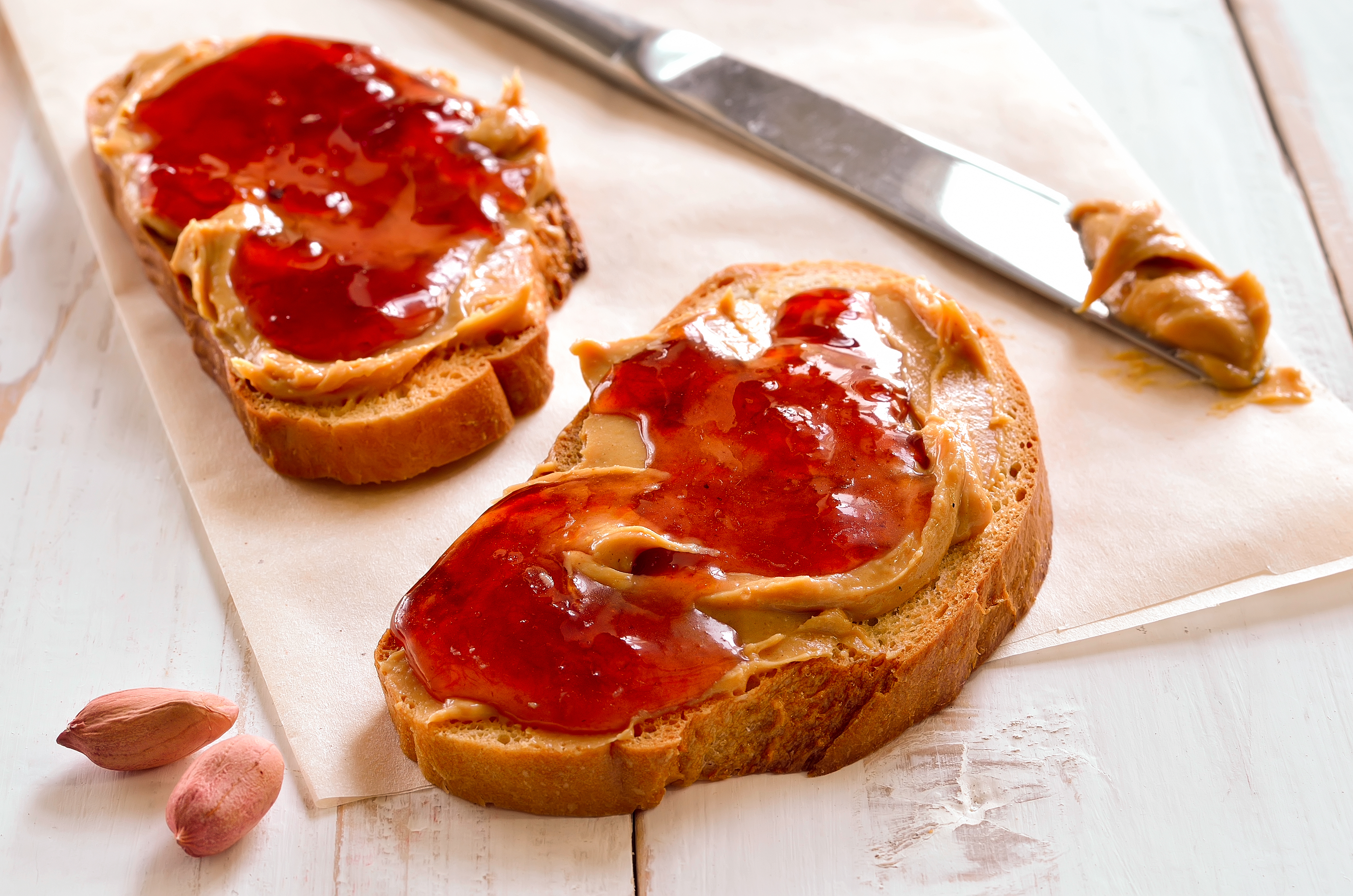Peanut butter sandwiches or toasts on light wooden background