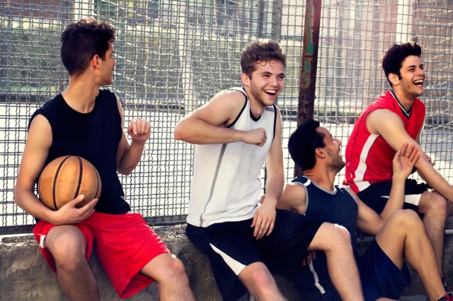 basketball players take a break sitting on a low wall