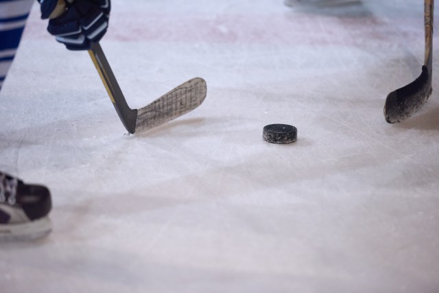 Ice hockey puck and two sticks during puck drop