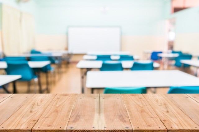 Look out from the table, blur image of empty classroom as background.