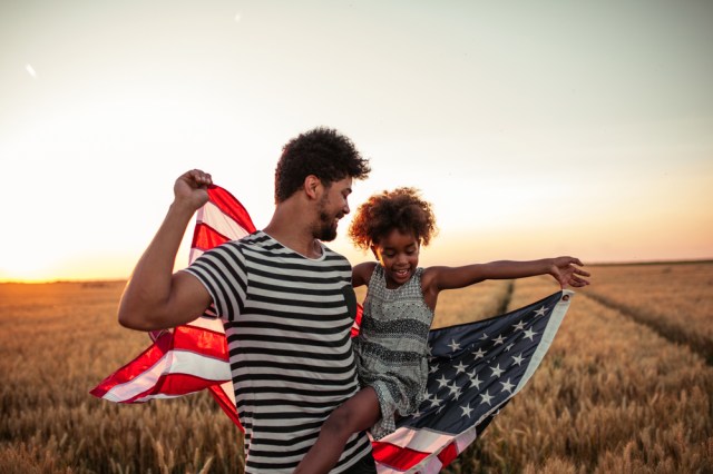 Father and daughter holding American flag