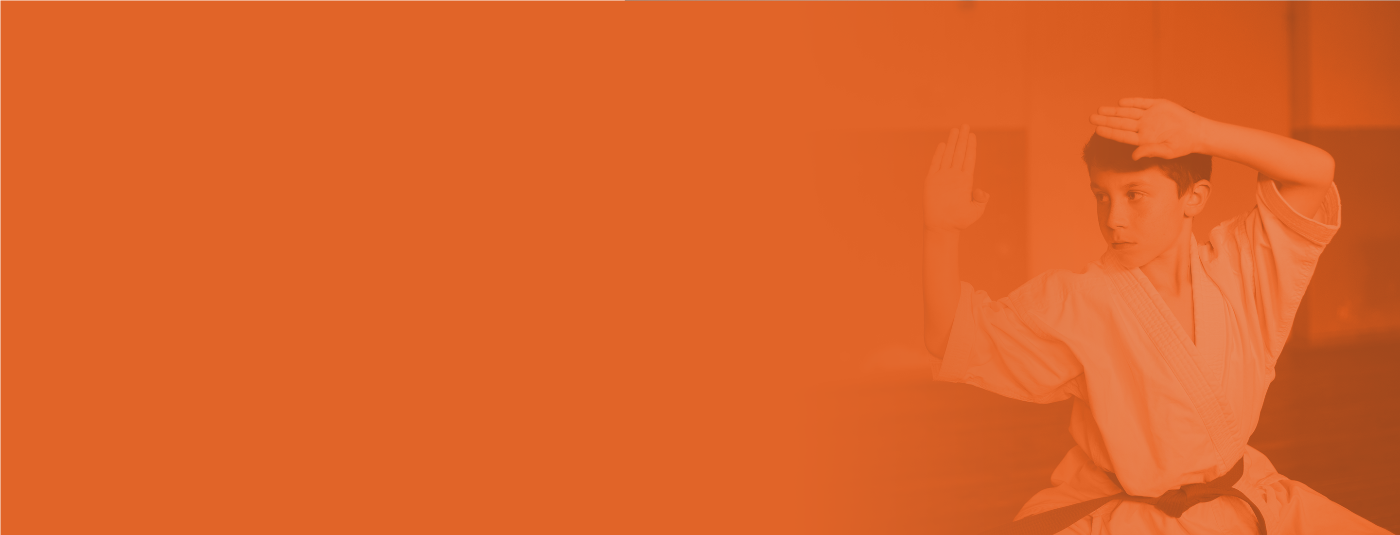 boy performing tae kwon do orange background