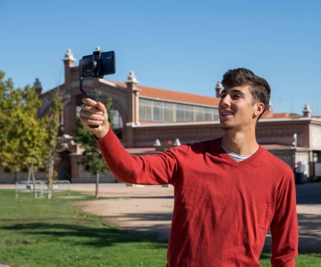 Man livestreaming on phone with tripod